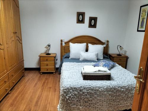 贝加德圣马特奥EL LLANETE的一间卧室配有一张带2个床头柜和2张桌子的床