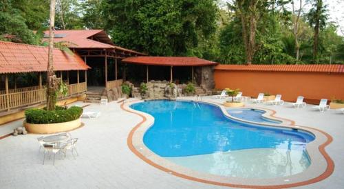 萨拉皮基沨竹萨尔瓦多酒店的一座带椅子的庭院和一座建筑中的游泳池