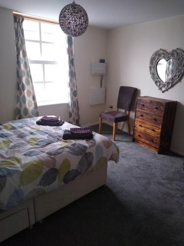 欣克利124A Castle Street Hinckley的卧室配有床、椅子和窗户。