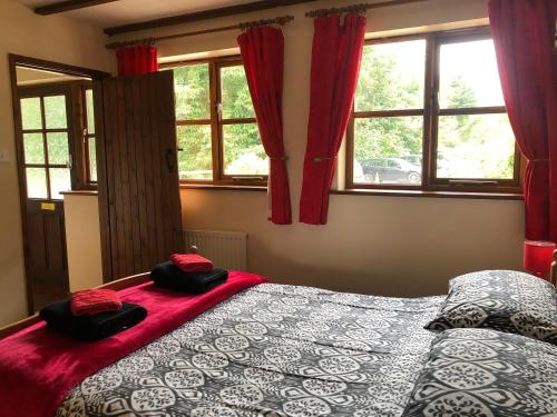 YorkleyDeanwood Holiday Cottages的一间卧室配有床和红色窗帘的窗户