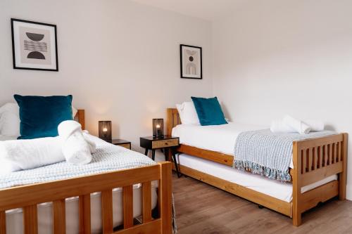 斯基普顿Sawley Cottage的配有蓝色枕头的客房内的两张床