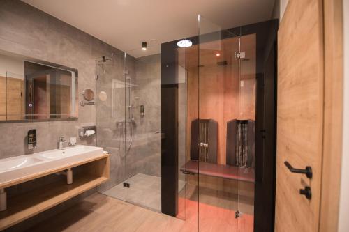 奥贝劳Das Lenz by Inncomer的一间带水槽和玻璃淋浴的浴室