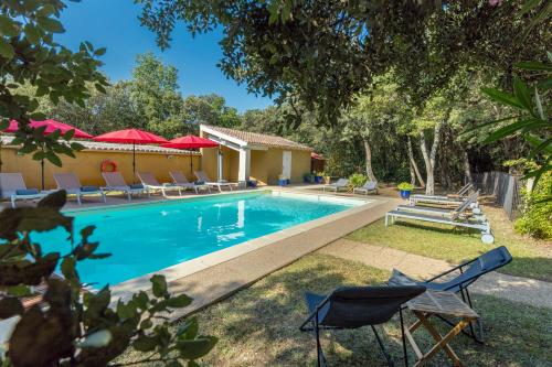 格里尼昂Logis La Bastide De Grignan Hotel & Restaurant "La Chênaie"的一个带椅子的游泳池以及一座房子