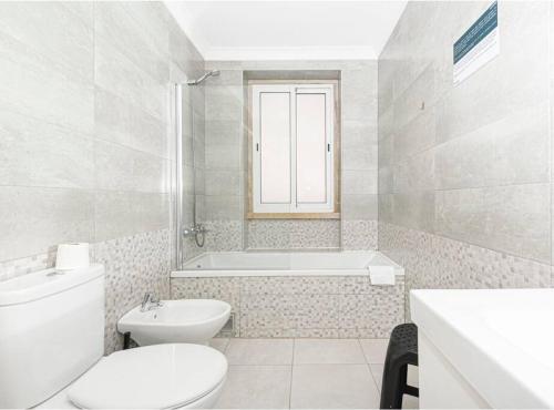 里斯本HOUZE_4 room flat in Central Lisbon near Zoo的白色的浴室设有卫生间和浴缸。