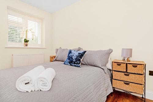 Sunbury CommonKempton Park Views -Two Double Bedroom Luxury Apartments的一间卧室配有带毛巾的床