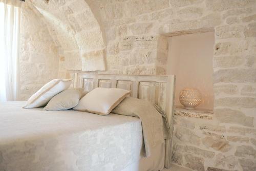 马丁纳弗兰卡Masseria Signora的一间卧室设有石墙和一张带枕头的床。