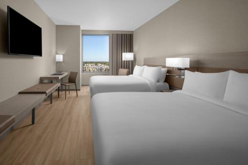 迈阿密AC Hotel by Marriott Miami Dadeland的酒店客房设有两张床和电视。