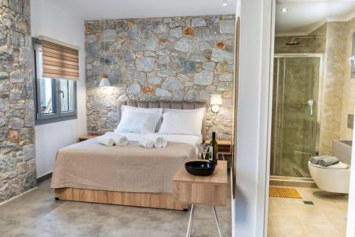 斯塔夫罗斯THALASSIA LUXURY APARTMENTS的一间卧室设有一张床和石墙