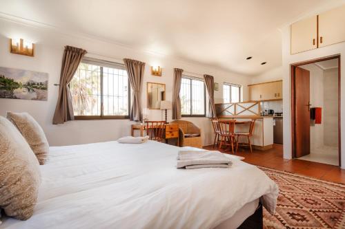开普敦Vlei Cove的一间带白色大床的卧室和一间厨房