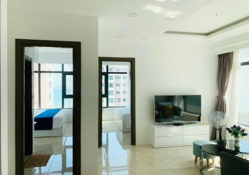 芽庄Ocean Dream Apartment Nha Trang的一间带床和电视的客厅