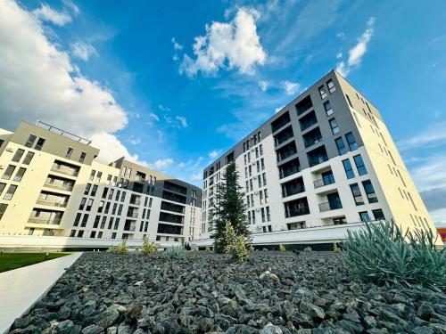 蒂米什瓦拉Modern Apartment in Timisoara的两座高大的建筑,有一大堆岩石