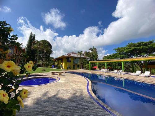 佩雷拉拉卡松纳生态酒店的一个带桌椅的度假村游泳池