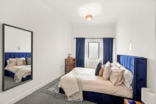 伦敦Luxury London Canary Wharf 2 bed apt的一间卧室配有两张床和镜子