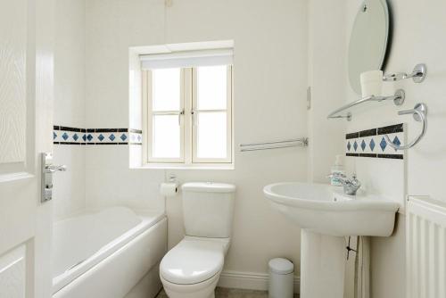 奇平卡姆登Gem Cottage的白色的浴室设有卫生间和水槽。