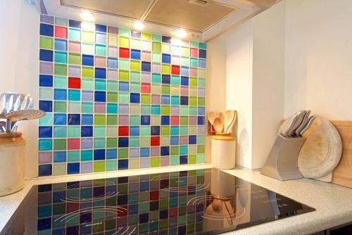奇平卡姆登Badgers End的厨房设有色彩缤纷的瓷砖墙