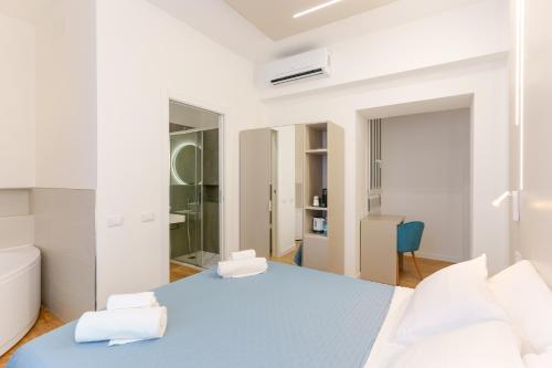 卡利亚里Aqua Comfort Rooms - Eja Sardinia的白色卧室配有蓝色的床和白色枕头