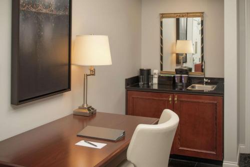波特兰Embassy Suites by Hilton Portland Downtown的办公室,带一张桌子,一台笔记本电脑和一盏灯