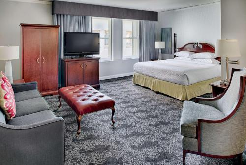 波特兰Embassy Suites by Hilton Portland Downtown的一间酒店客房,配有一张床和一台电视