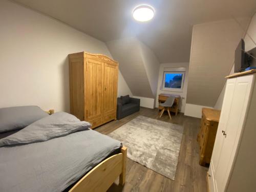 拜罗伊特Colmdorf Ferienhaus的一间卧室配有一张床和一个木制橱柜