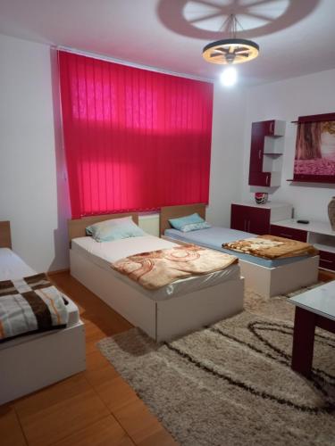 布尔奇科Arthur 2的一间卧室设有两张床和红色的墙壁