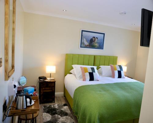 斯坦利Tu Guesthouse的一间卧室配有两张带绿色床头板的床