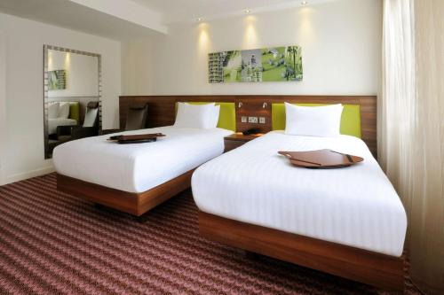 谢菲尔德希尔顿谢菲尔德汉普顿酒店的配有白色床单的酒店客房内的两张床