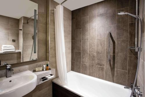 爱丁堡希尔顿爱丁堡卡尔顿酒店的带浴缸、水槽和淋浴的浴室