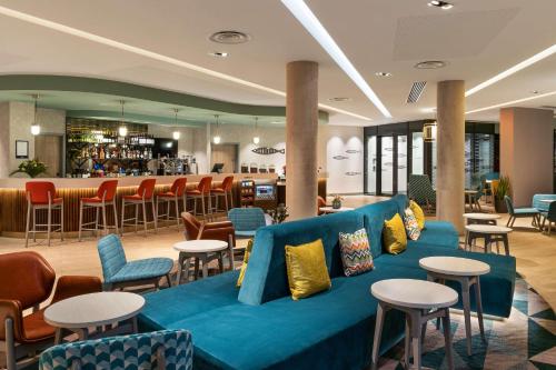 托基Hampton By Hilton Torquay的大堂设有蓝色的沙发和桌子,酒吧