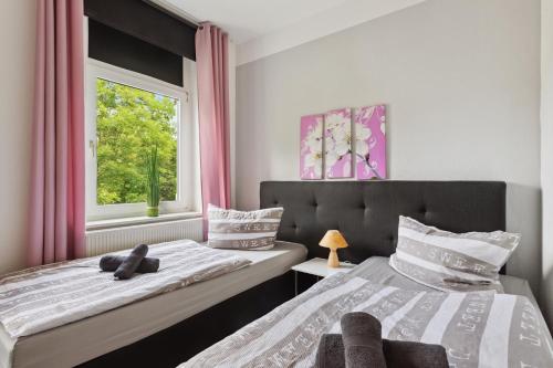 哈尔伯施塔特Schönes Ferien-Appartement für bis zu 6 Personen的一间卧室设有两张床和窗户。