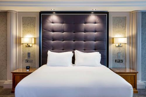 格拉斯哥格拉斯哥中心希尔顿逸林酒店的一间卧室配有一张大床和大床头板
