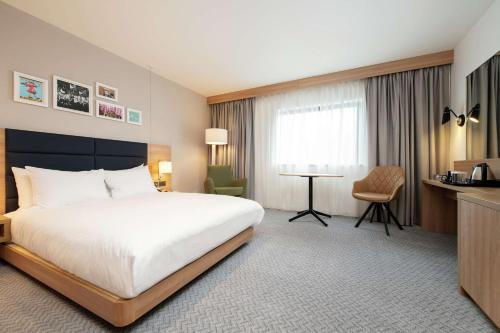 阿宾登Hilton Garden Inn Abingdon Oxford的酒店客房设有一张大床和一张书桌。