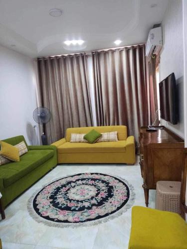 Al Ḩammādبلطيم的客厅配有黄色沙发和地毯。