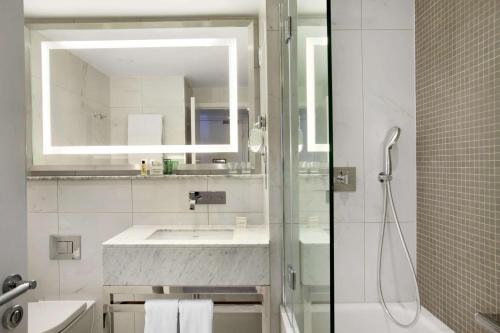 伦敦希尔顿伦敦伊斯灵顿天使酒店的白色的浴室设有水槽和淋浴。