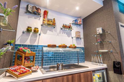 伦敦DoubleTree by Hilton London Angel Kings Cross的厨房设有水槽和蓝色瓷砖墙。