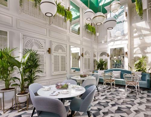 伦敦100 Queen’s Gate Hotel London, Curio Collection by Hilton的用餐室配有桌椅和植物