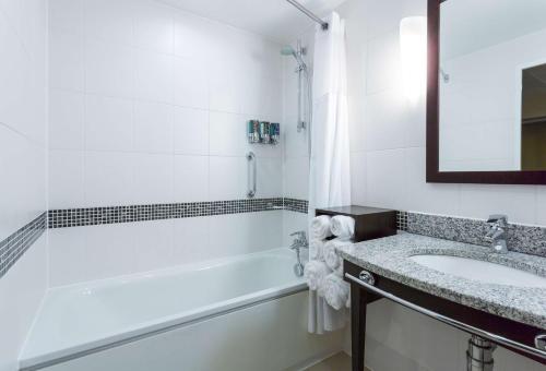斯皮克希尔顿汉普顿利物浦约翰·列侬机场酒店的白色的浴室设有水槽和浴缸。