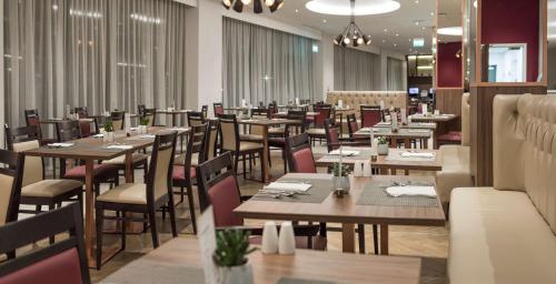 曼彻斯特老特拉福德旅馆的用餐室配有木桌和椅子