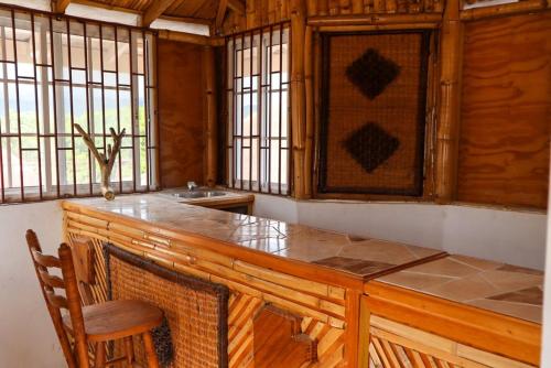 布莱克河Kokojo Villa的厨房配有带椅子和窗户的大型木制柜台。