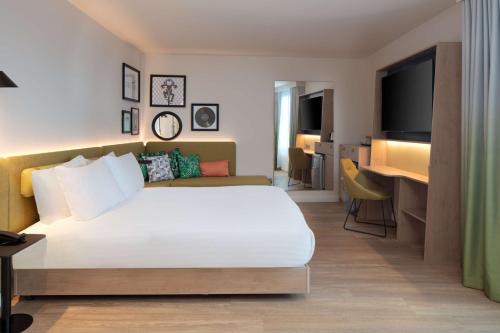约克Hampton by Hilton York Piccadilly的酒店客房,配有床和电视