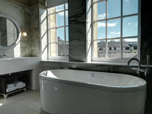 爱丁堡爱丁堡市中心希尔顿逸林酒店的带窗户的浴室内的白色浴缸