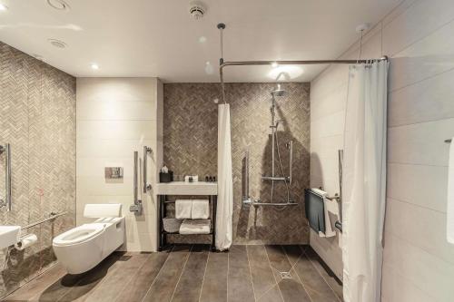 剑桥The Fellows House Cambridge, Curio Collection By Hilton的浴室配有卫生间、盥洗盆和淋浴。