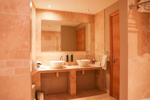 米尔顿凯恩斯希尔顿米尔顿凯恩斯双树酒店的浴室设有2个水槽和镜子