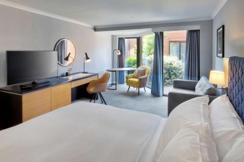 霍尔DoubleTree by Hilton Manchester Airport的酒店客房配有一张床和一张书桌及一台电视