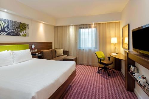 克罗伊登希尔顿汉普顿伦敦克罗伊登酒店的酒店客房设有一张大床和一张书桌。