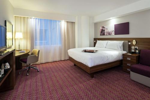 霍利希尔顿汉普顿伦敦盖特威克机场酒店的酒店客房设有一张床、一张书桌和一台电视机。
