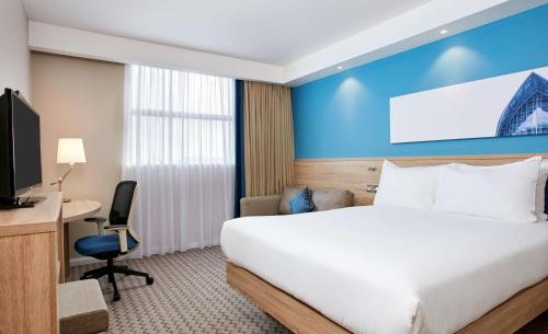 格拉斯哥格拉斯哥市中心希尔顿汉普顿酒店的酒店客房设有一张床、一张书桌和一台电视机。