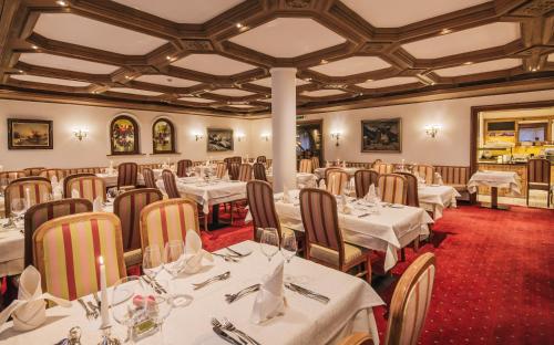 圣安东阿尔贝格格雷斯豪夫酒店的一间设有白色桌椅的用餐室