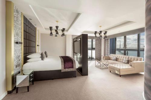 北昆斯费里爱丁堡希尔顿逸林酒店 - 昆斯费里路口的一间卧室配有一张床、一台电视和一张沙发