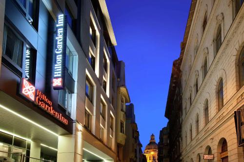 布达佩斯Hilton Garden Inn Budapest City Centre的建筑物一侧的灯光标志