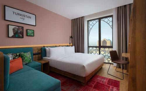 TürkistanHampton By Hilton Turkistan的酒店客房,配有床和沙发